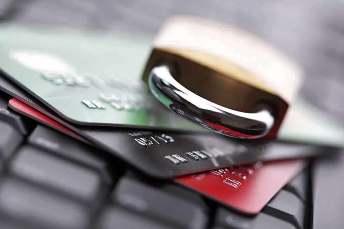 A padlock resting on top of multiple credit cards on a keyboard