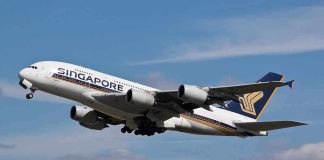 Singapore Airlines airplane taking off against a blue sky